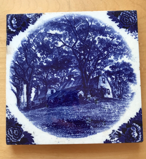 Image of ceramic tile depicting “The Homestead of The Fairbanks Family in America" in blue upon a white base.
