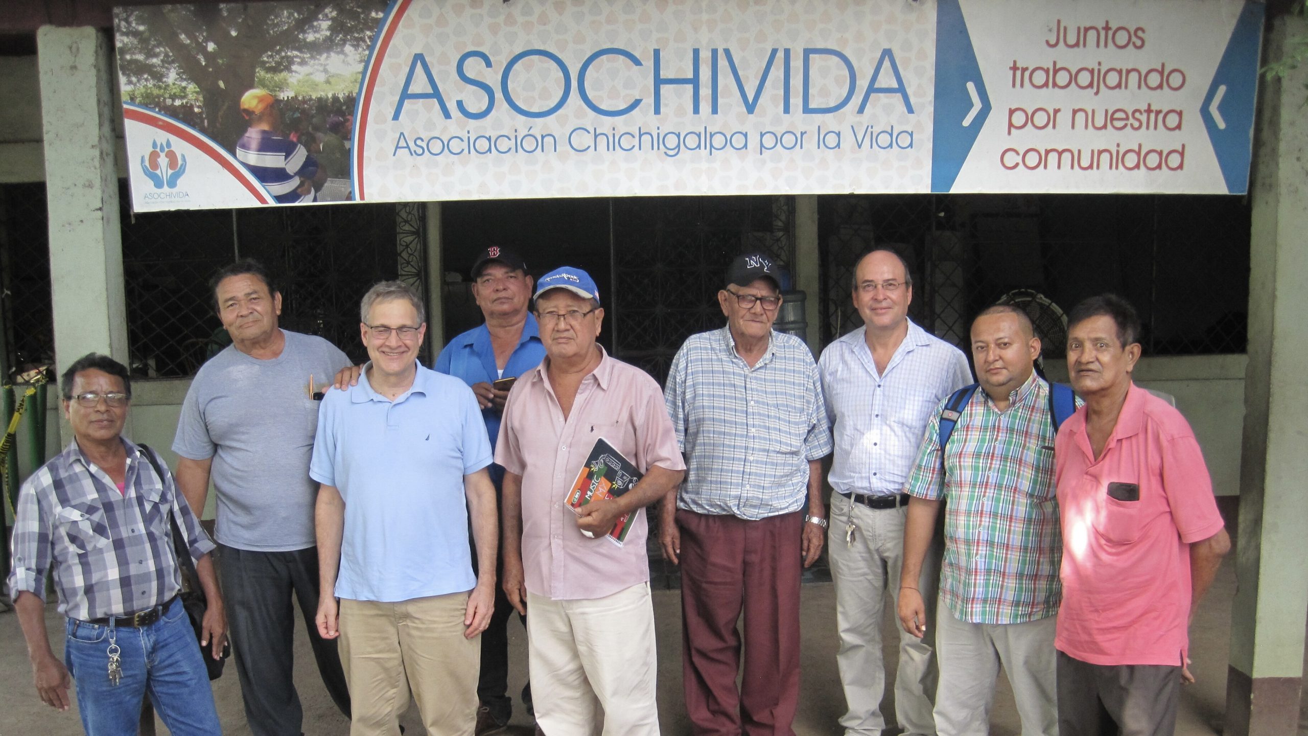 a group picture of Dr. Brooks and ASOCHIVIDA. The team is standing in front of the ASOCHIVIDA entrance.