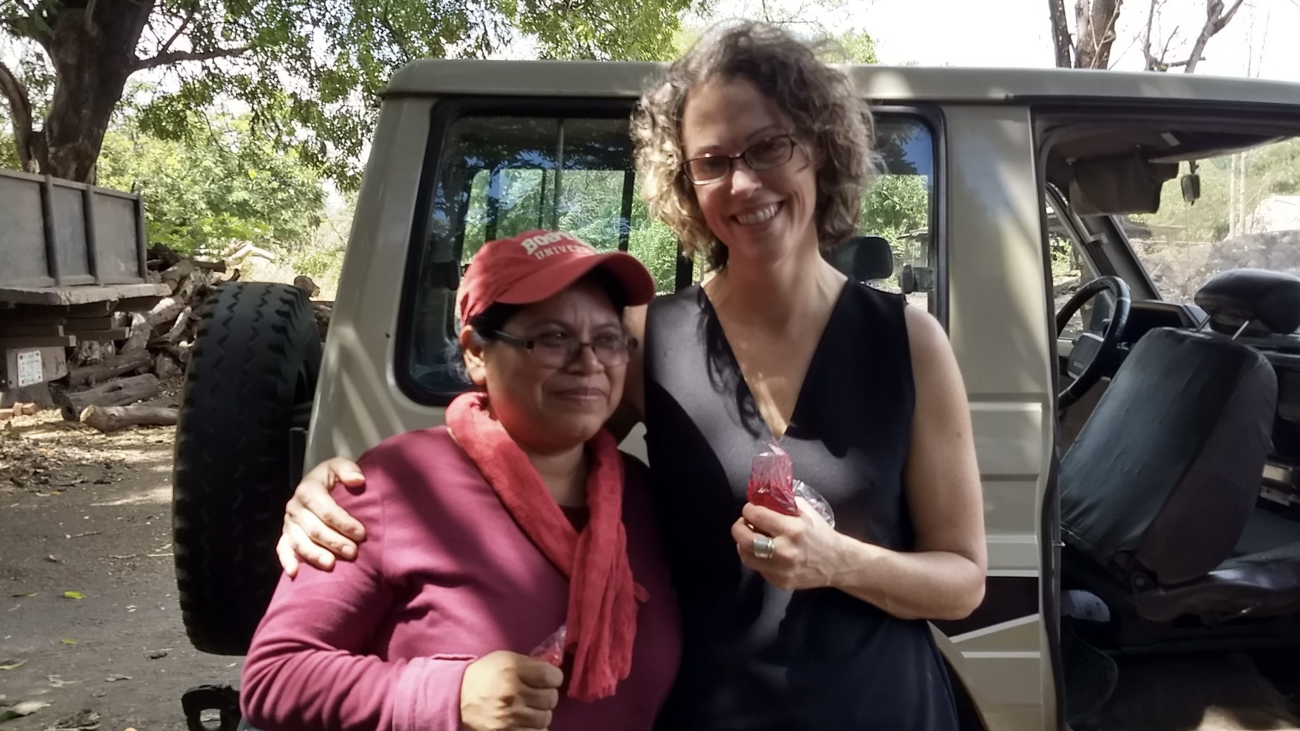 Damaris López and Dr. Scammell are standing in front of a car looking at the camera and smiling.