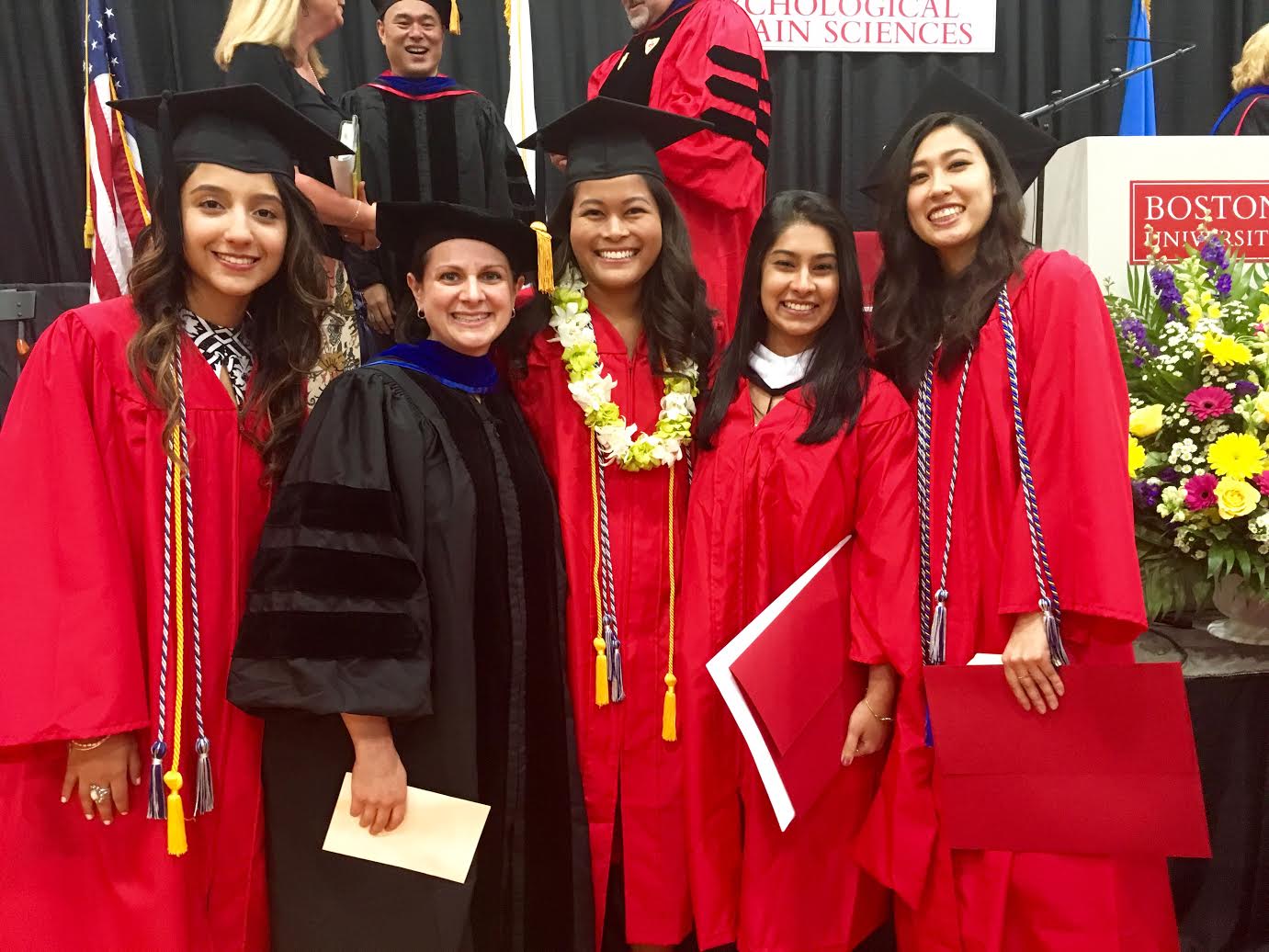 alt="photo of Director with Recent Graduates of Lab in Graduation Regalia."