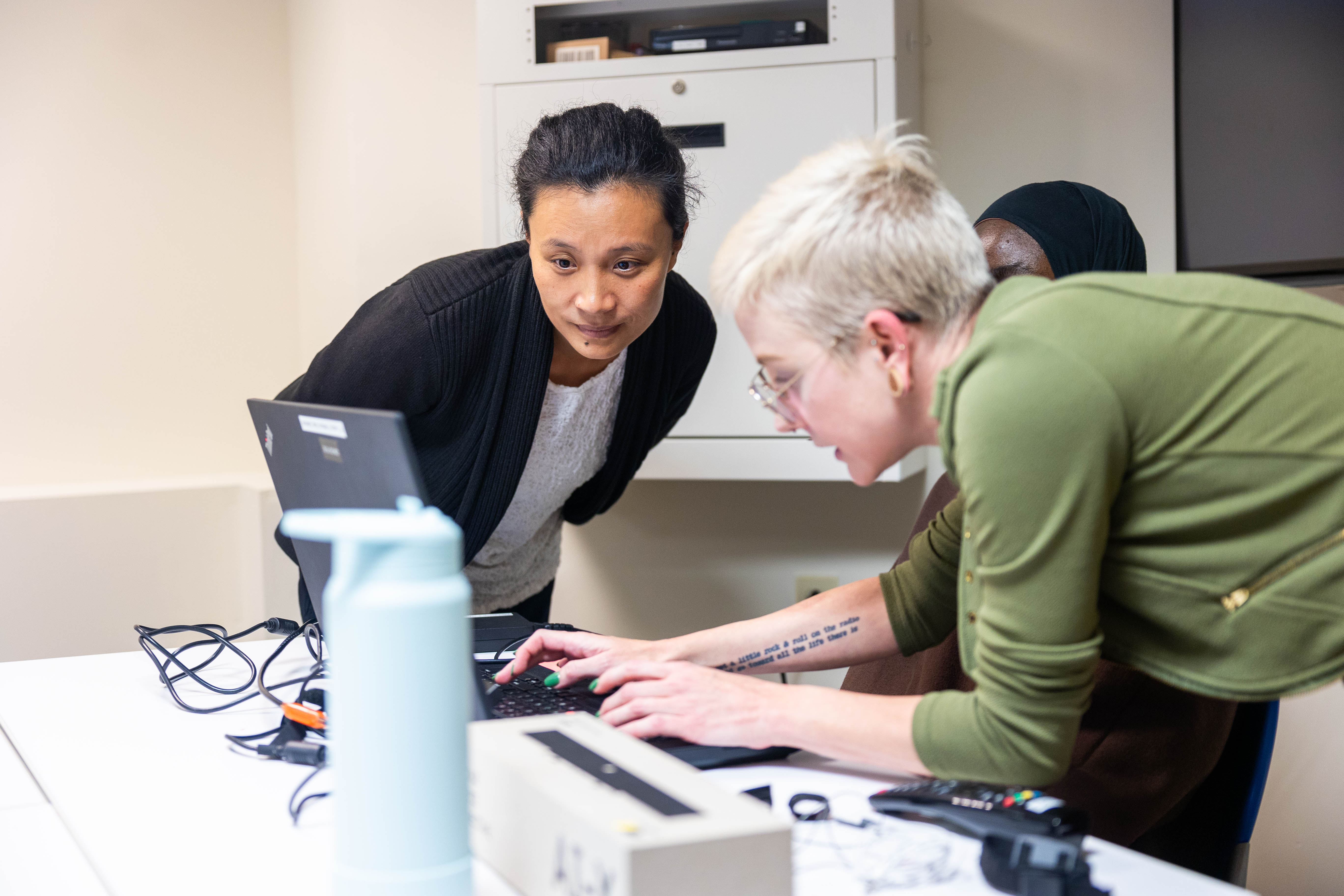 An image of faculty from BU's School of Hospitality and the CRC Lab Manager, Amanda King, prepping a graduate student for biometric data collection.