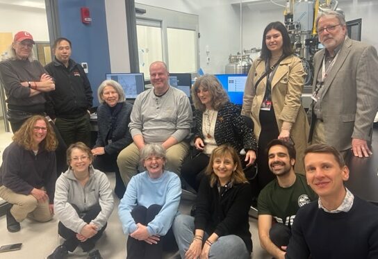 members of the PPB team sitting in the control room of the cryoEM core facility posing for a photo