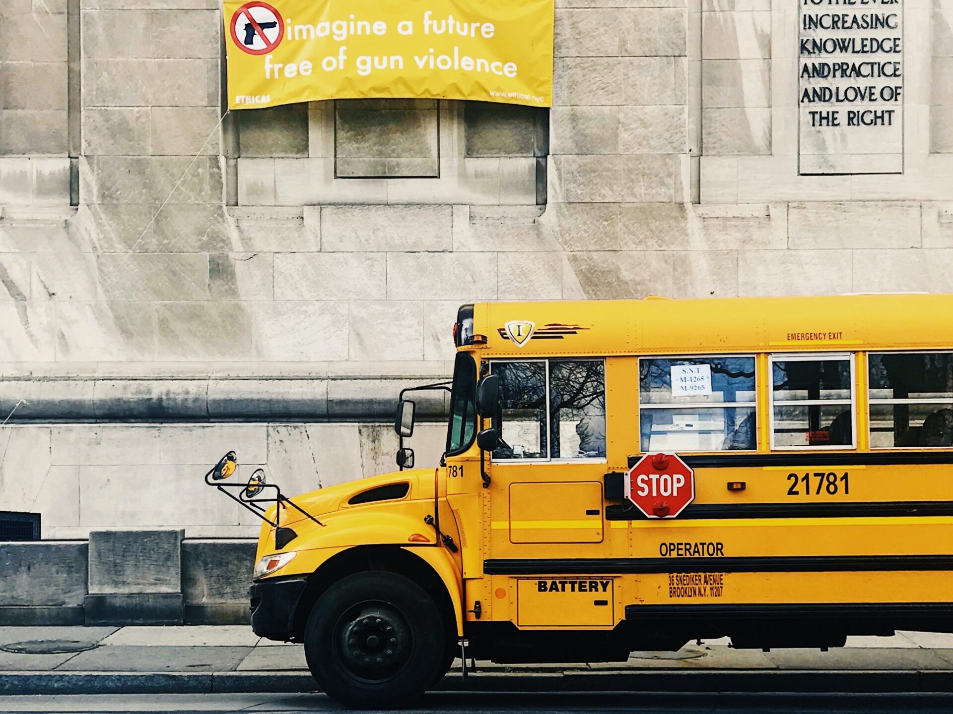 School bus in front of sign "Imagine a future free of gun violence"