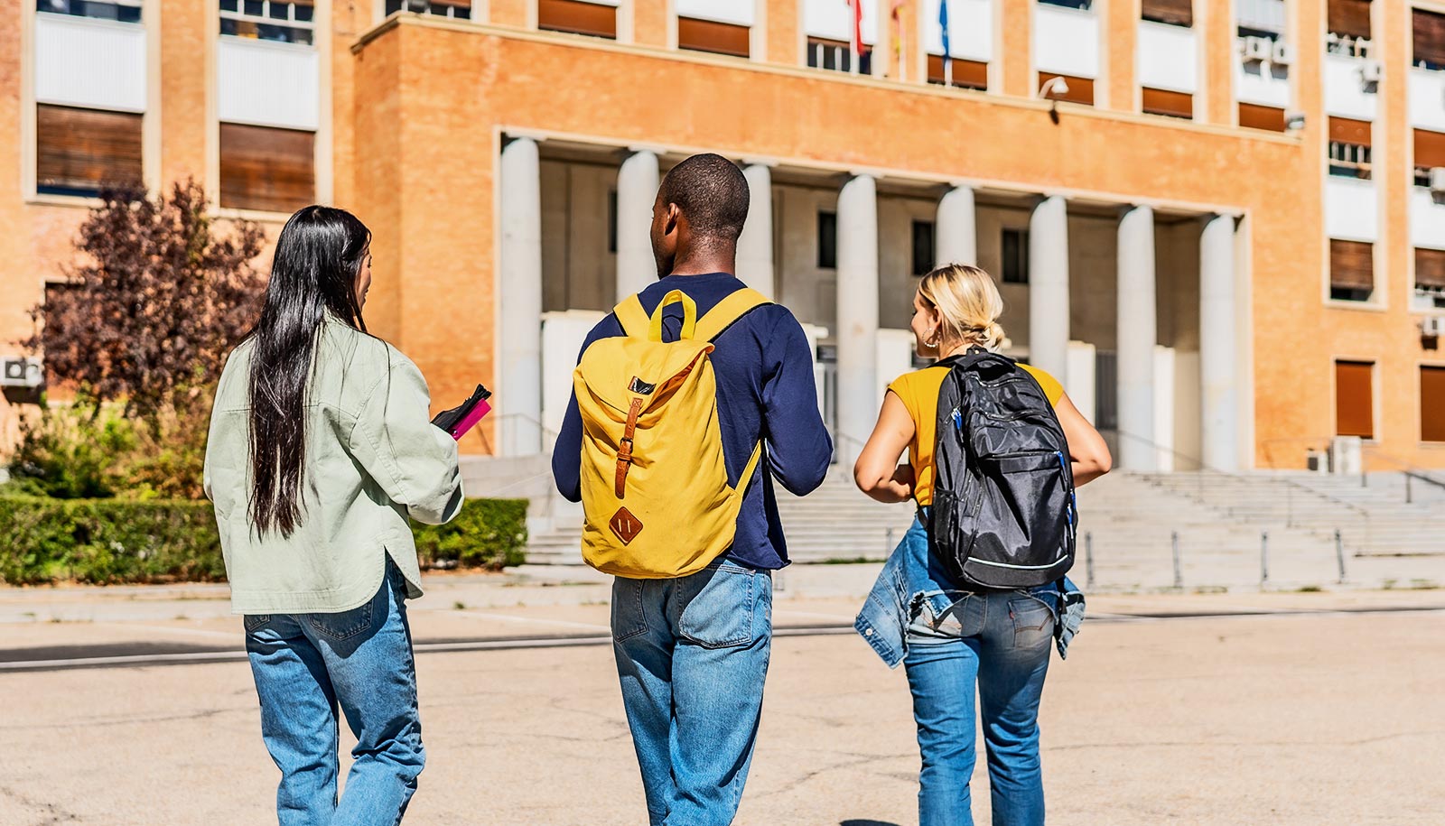 Three college students walk together on campus