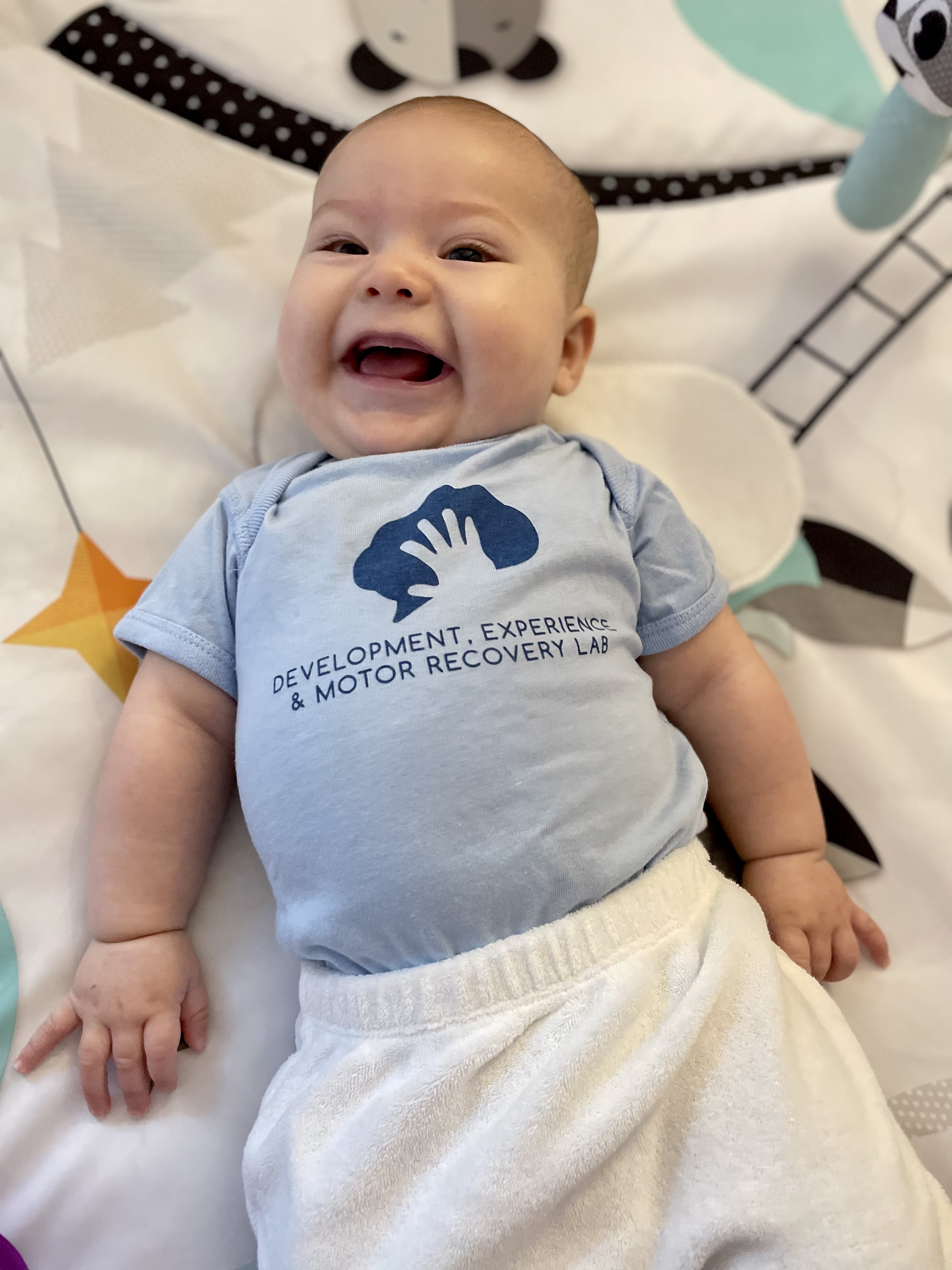 Infant participant wearing DEMR Lab onesie