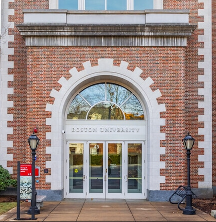 The image shows the main entrance doors for Hawes Main Street. It consists of 4 glass doors and "Boston University" sign is above the doors.