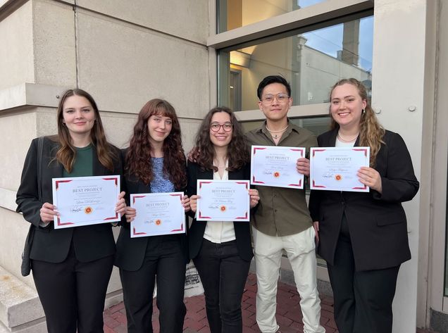 Raina Tung (middle) and her senior design team with their "Best Project" award.