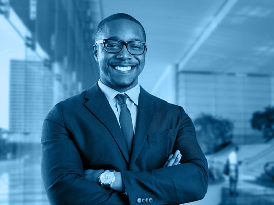 A businessman posing in the lobby of a large building