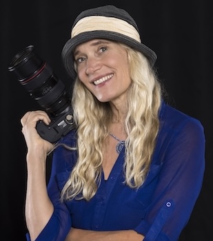 Julia Cumes posing with a camera.