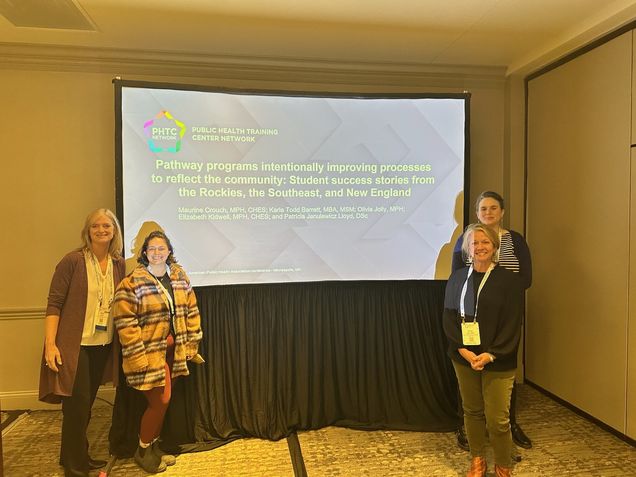 From left to right: Laura Lloyd, Candice Bangham, Olivia Jolly, Maurine Crouch standing in front of the APHA PowerPoint slides 