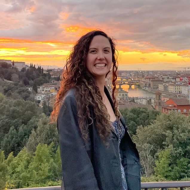 Headshot of a woman in front of a sunset with trees in the background