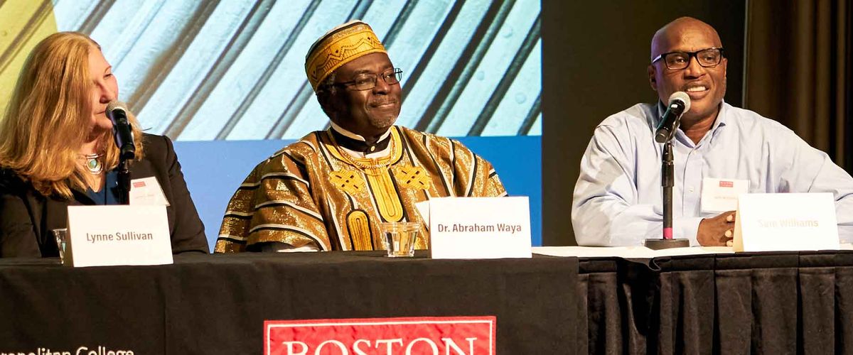 A panel of presenters speaking in a conference hall