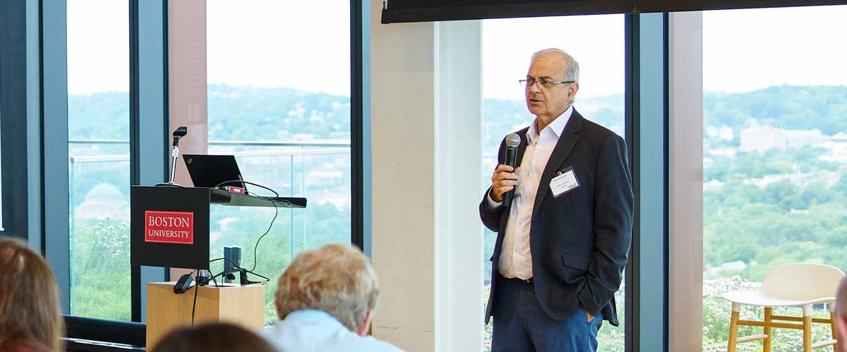 Associate Professor Vijay Kanabar delivers a speech to a large audience in a conference room