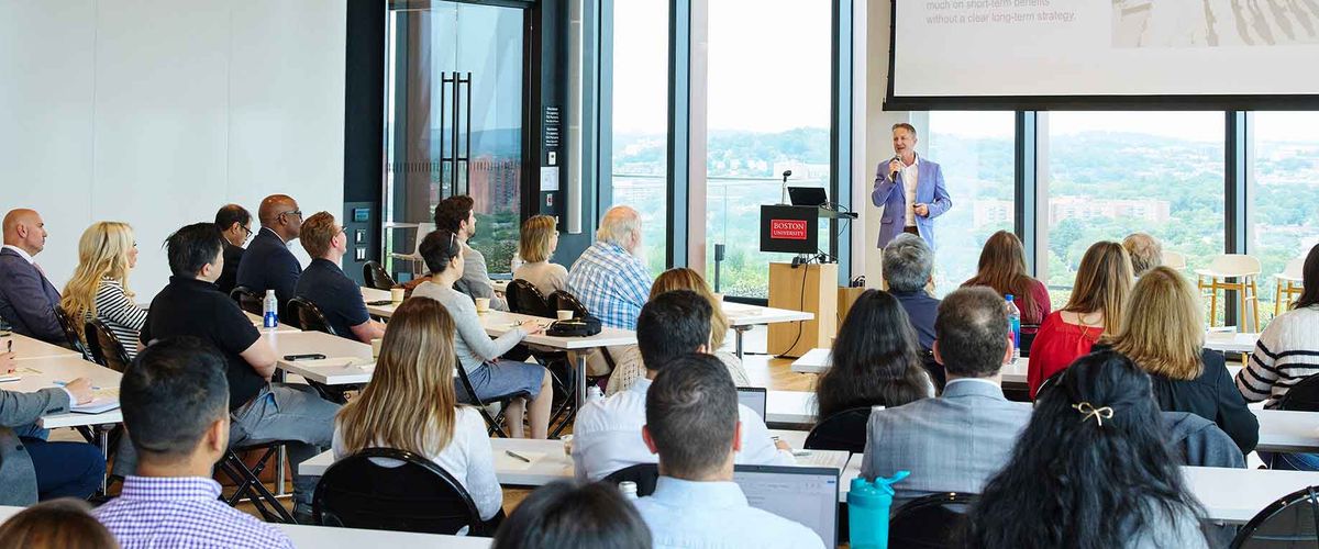 A speaker presents to a large audience at the 2025 PMiP Conference