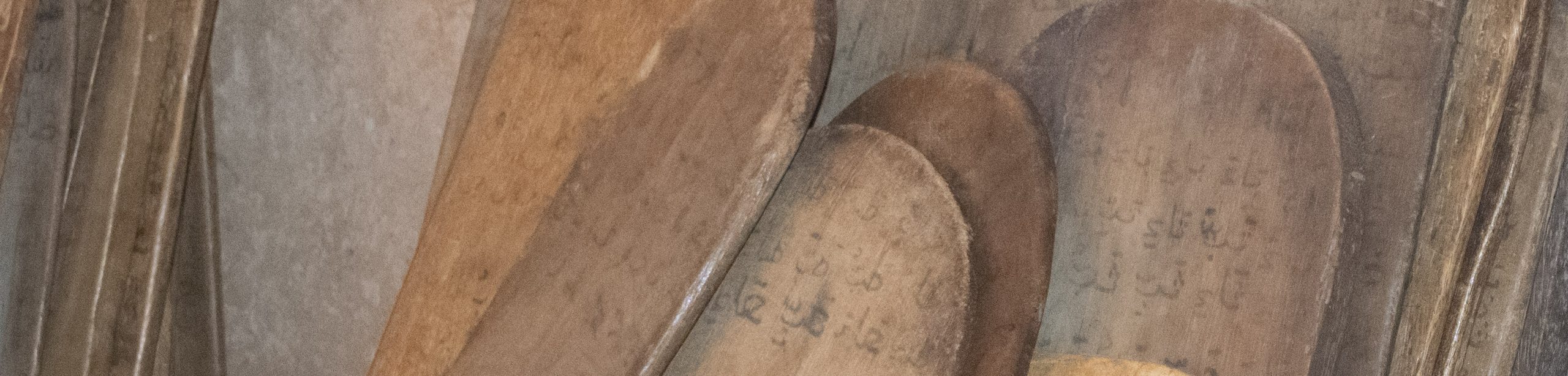 Wooden tablets used in Senegambian Quranic schools where students acquire dual literacy in classical Warsh Arabic script and Ajami.