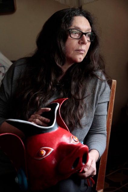 Alicia Martínez Álvarez sitting in a chair, holding a red mask.